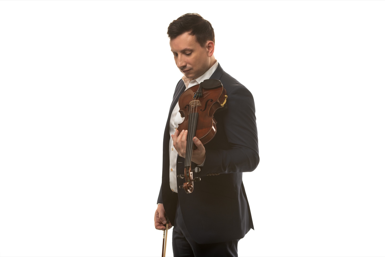 François Mathian standing with his violin on a white background